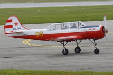 Rød og hvit Jak-52 med nummer 09 på taksebanen