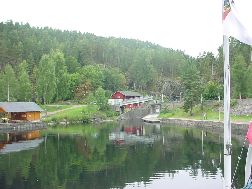 Løveid sluser sett fra nedsiden, med et rødt hus ved slusekammeret