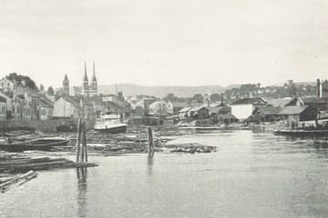 Skien havn i 1896, med tømmerflåter i elva og kirketårnene bak