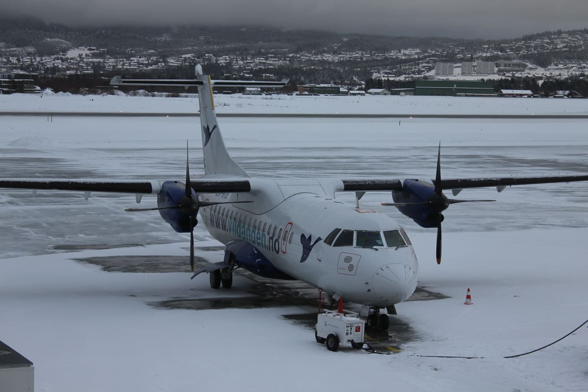 ATR 42 med villanda på halen, parkert i snøen på Værnes